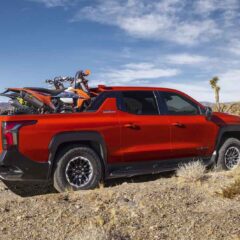 Dirt bikes in the bed of the 2026 Silverado EV in Habanero Orange, demonstrating the length of the bed with the Midgate down.
